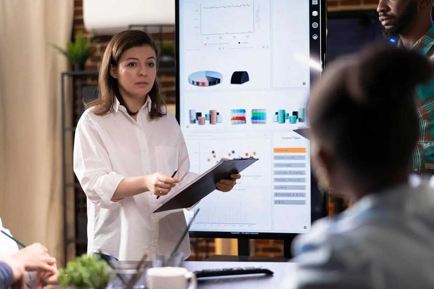 Mujer caucásica presenta planes de proyecto con un portapapeles.